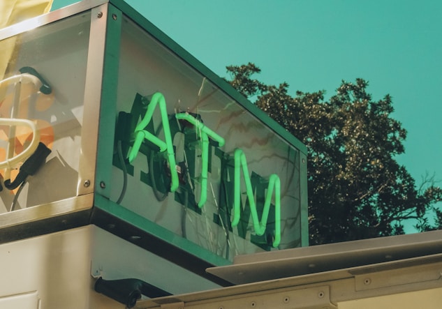 a sign that says atm on the side of a building