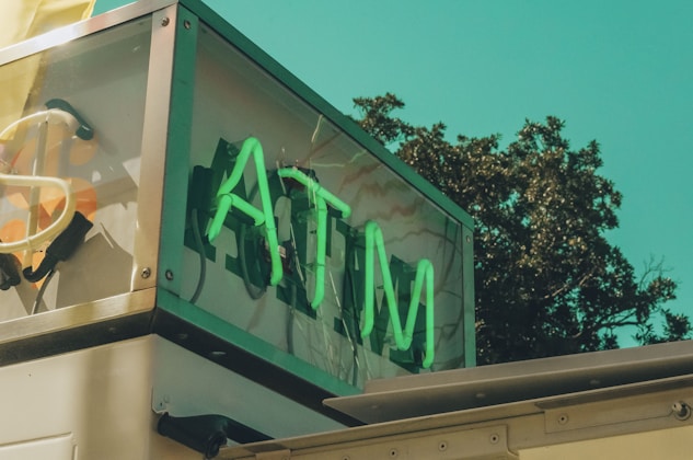 a sign that says atm on the side of a building