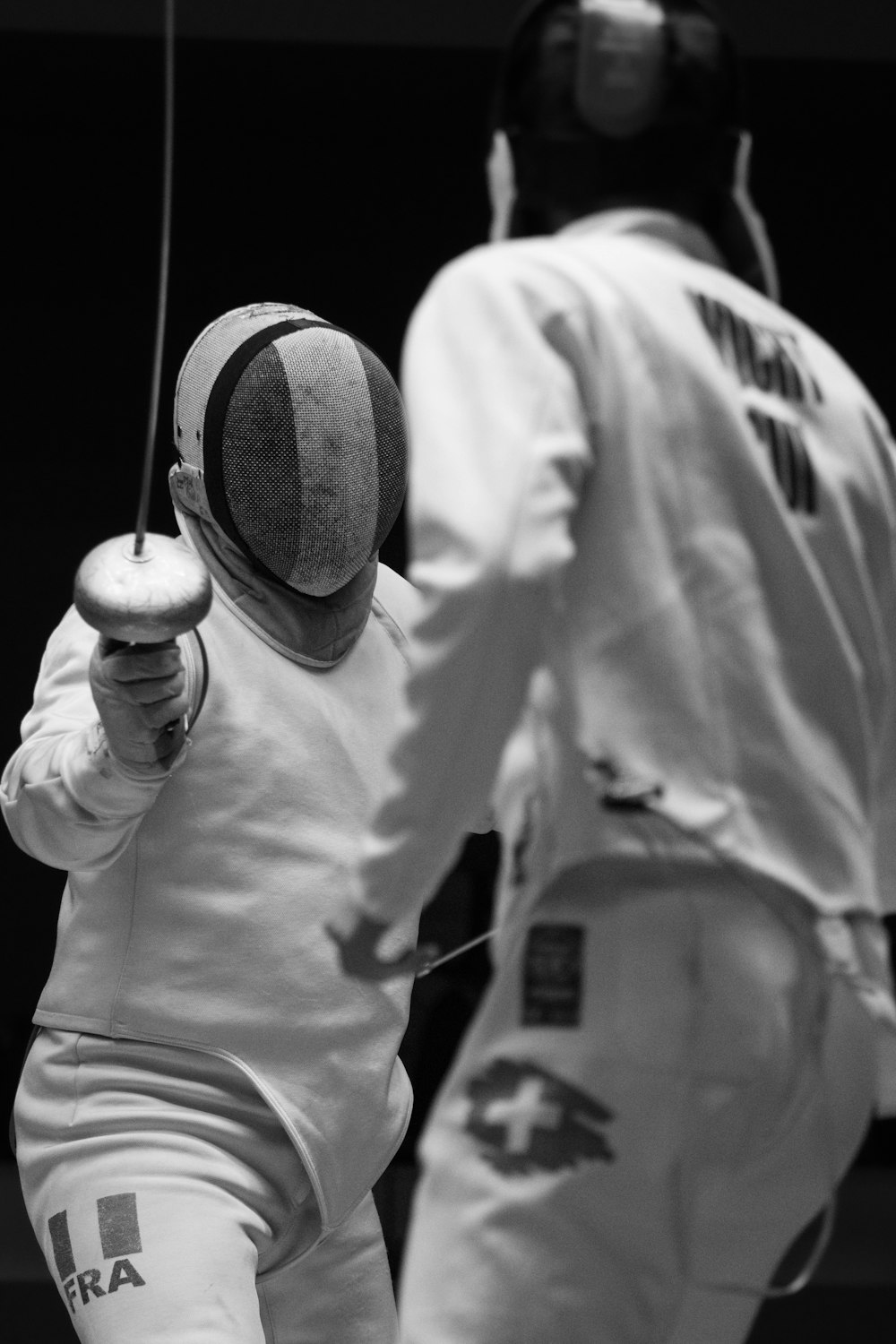 two men in fencing gear practicing their moves