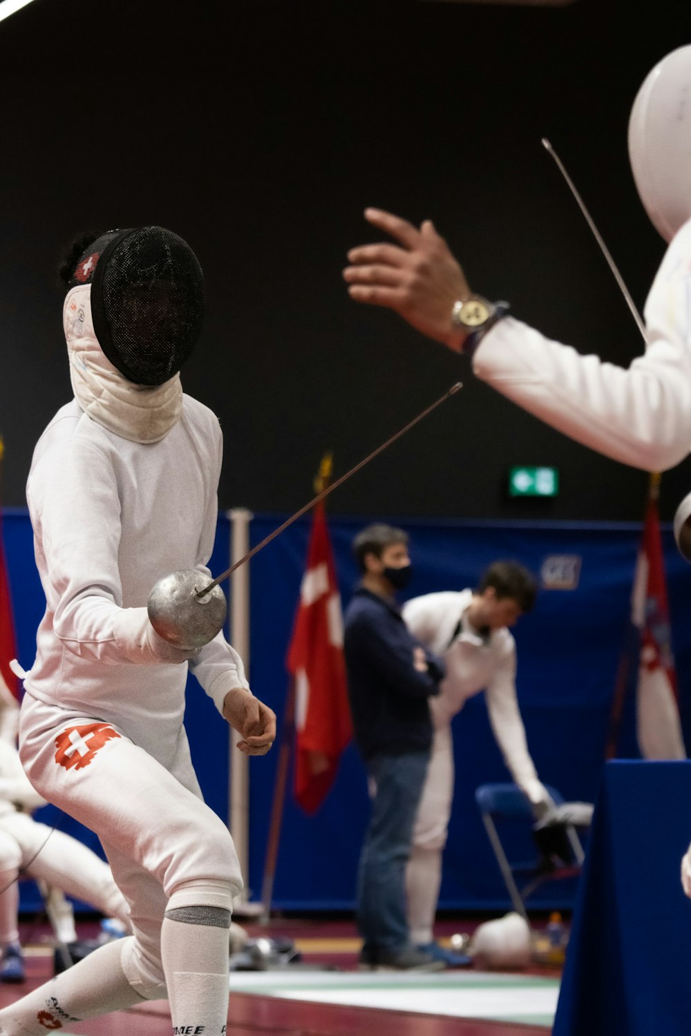 a group of people on a court with fencing equipment