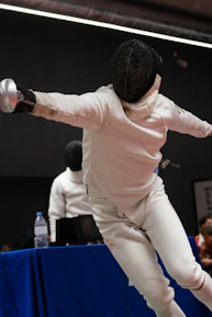 Close-up of a fencer's hand gripping a foil, highlighting precision and focus.