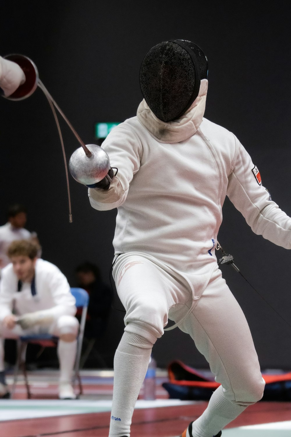 a person in a fencing suit with a ball in the air