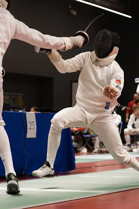 two people in fencing gear on a court