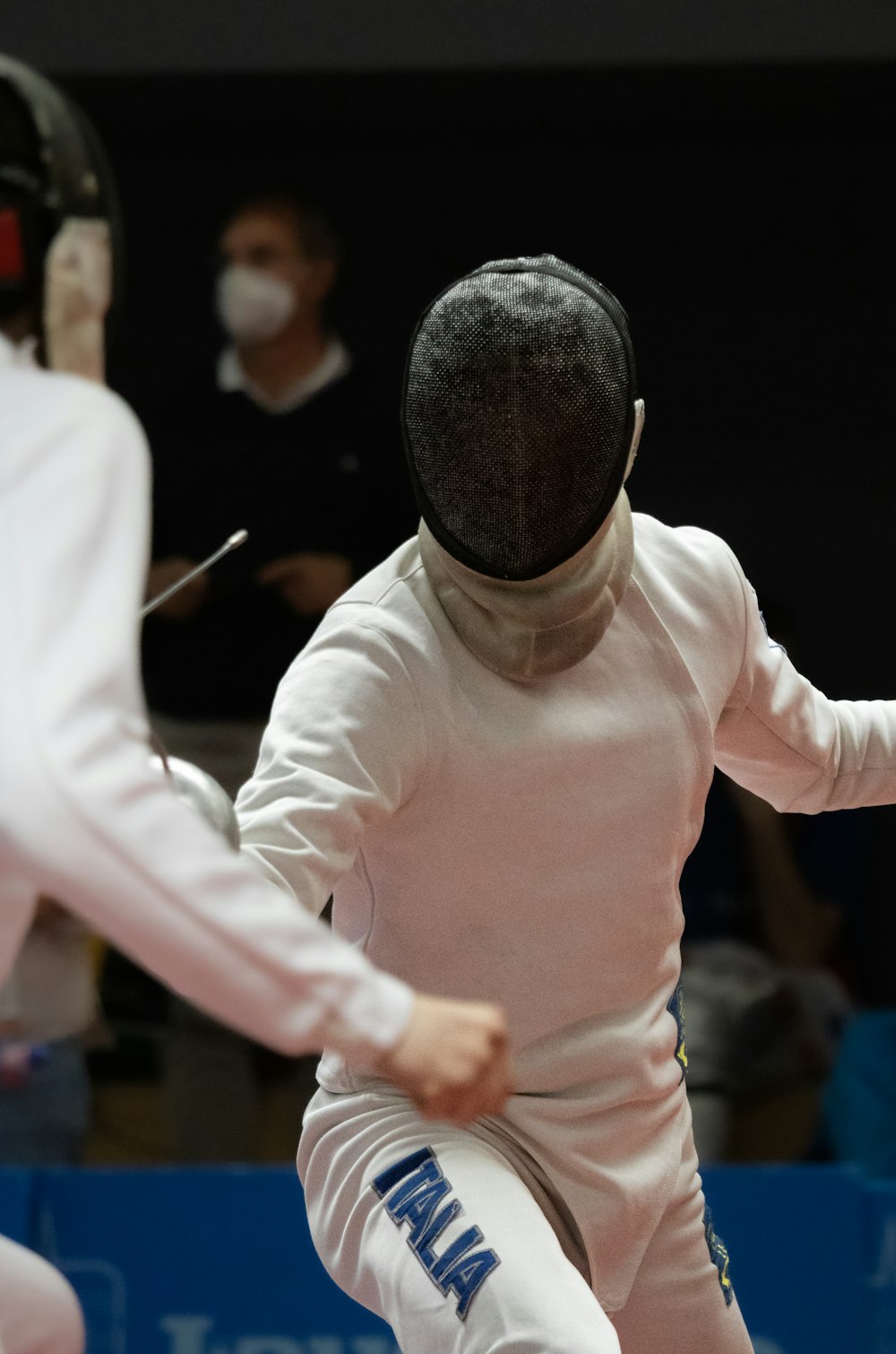 a person in a fencing suit and a person in a mask