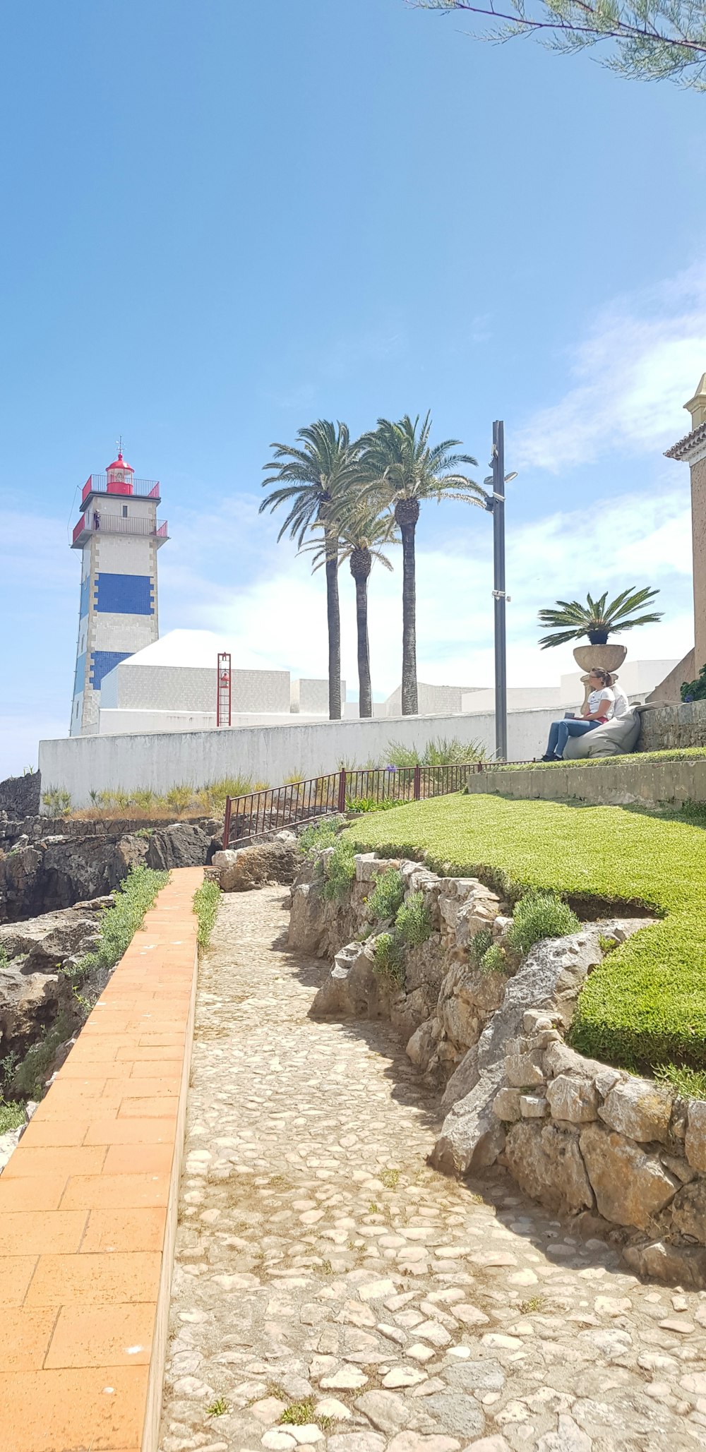 a pathway leading to a lighthouse on a sunny day