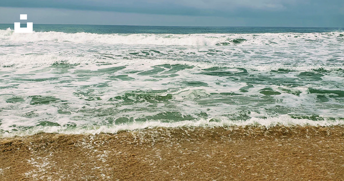 Une plage de sable avec des vagues qui arrivent sur le rivage photo ...