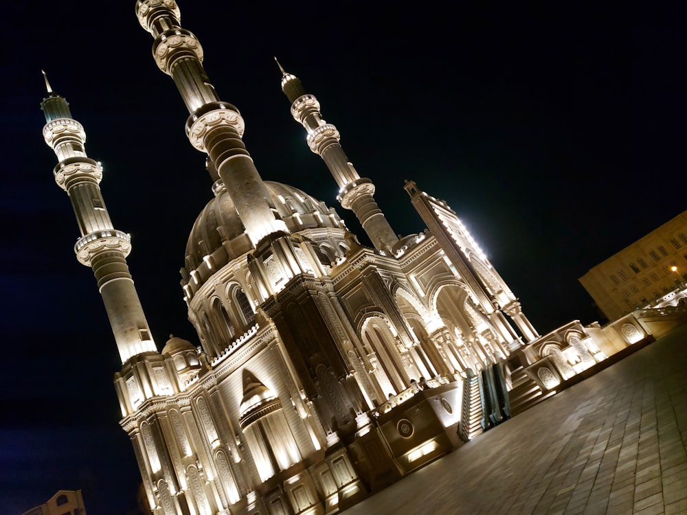 a large building lit up at night with a sky background