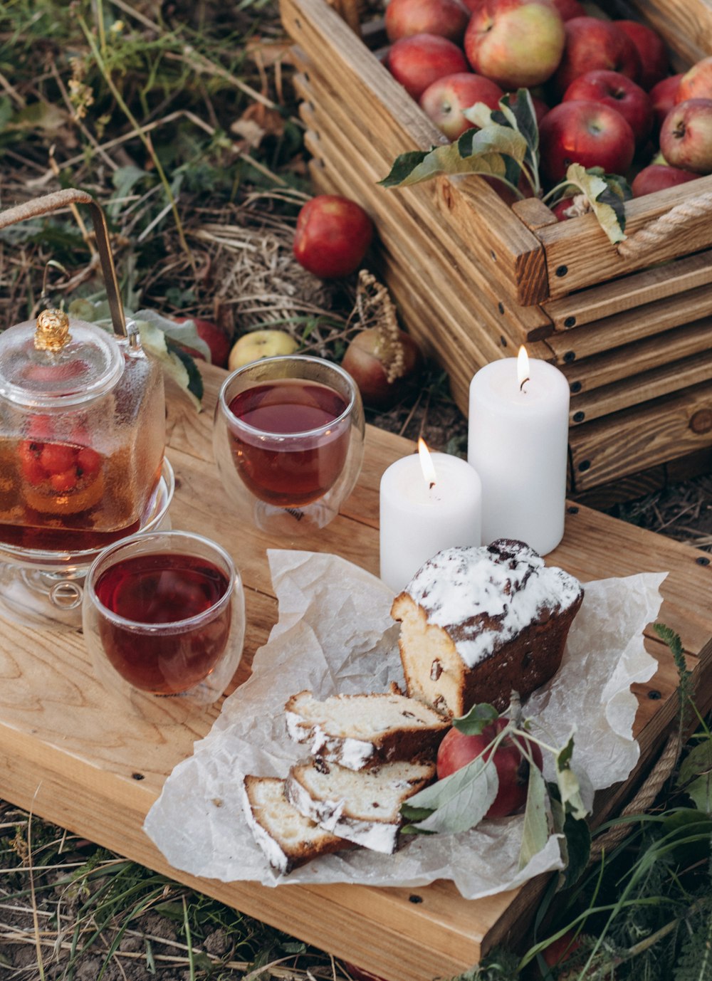 a wooden tray topped with a slice of cake next to a cup of tea