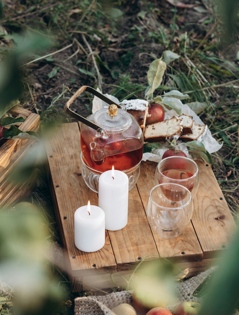 a wooden tray topped with drinks and a candle