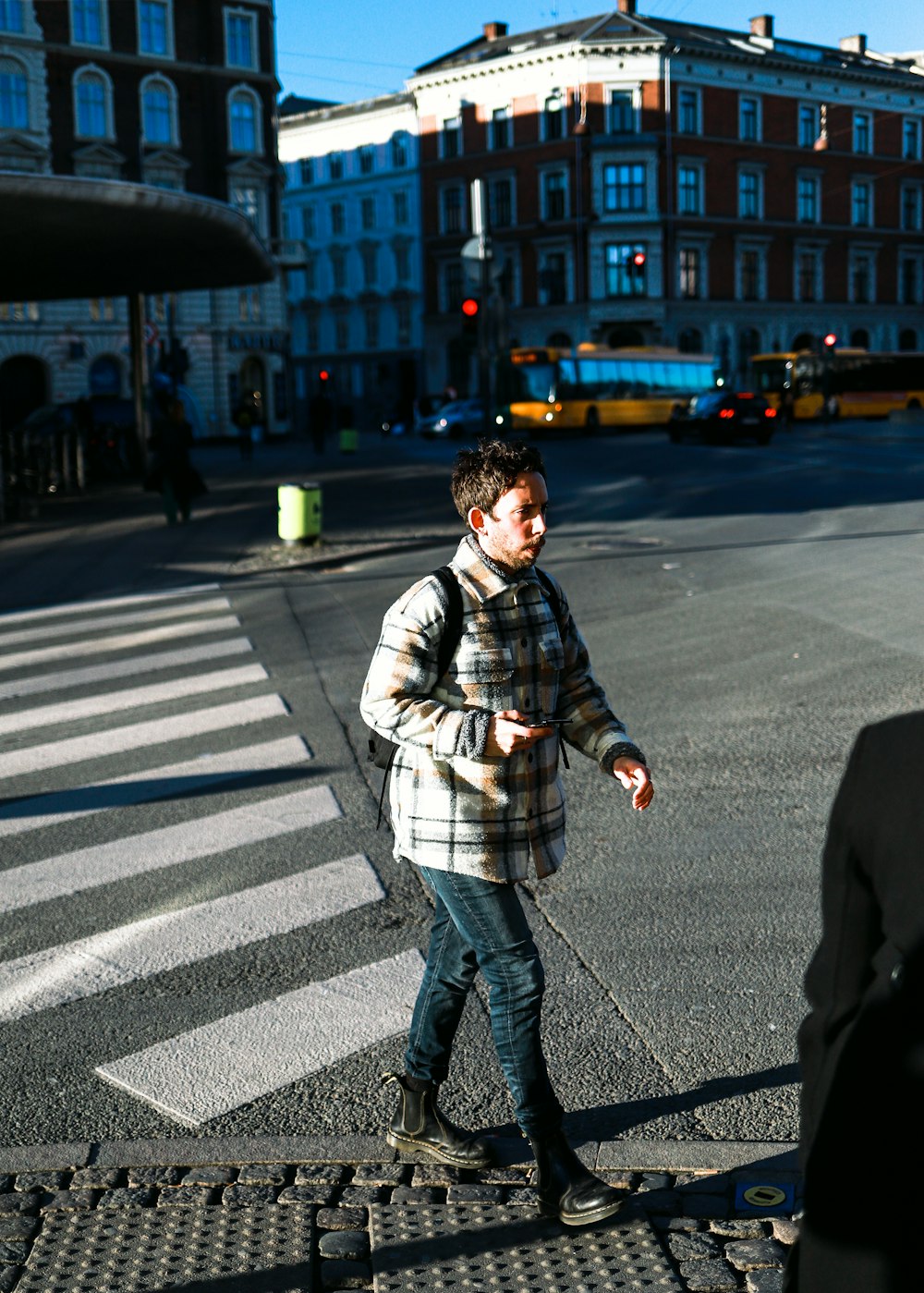 a man walking across a street next to a cross walk