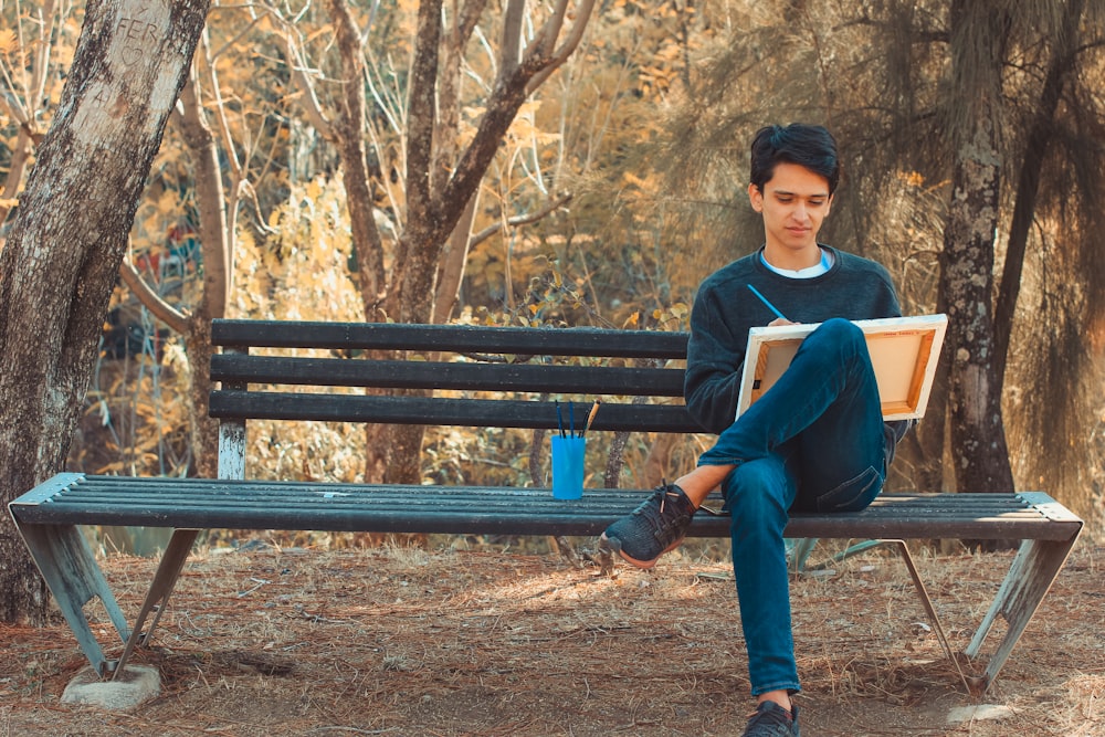 a man sitting on a bench reading a book