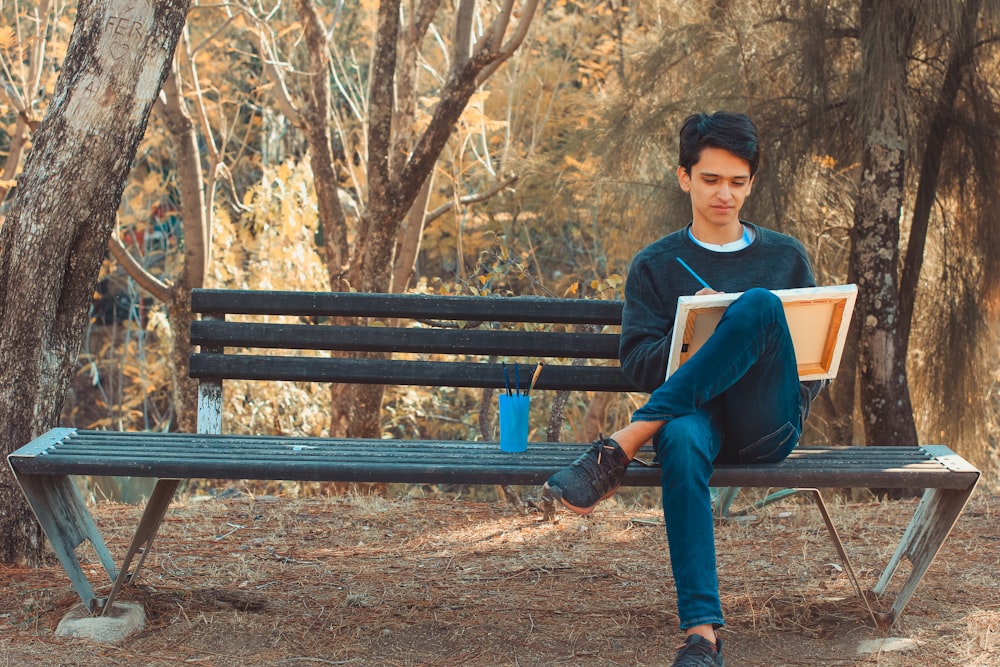 Un hombre sentado en un banco leyendo un libro