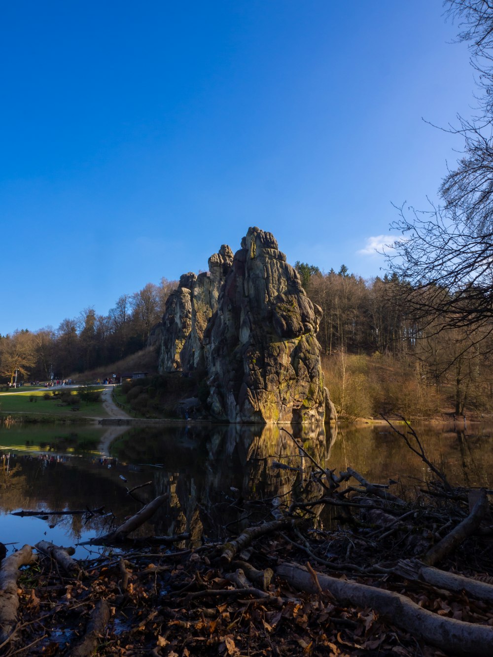 a lake surrounded by trees and a large rock