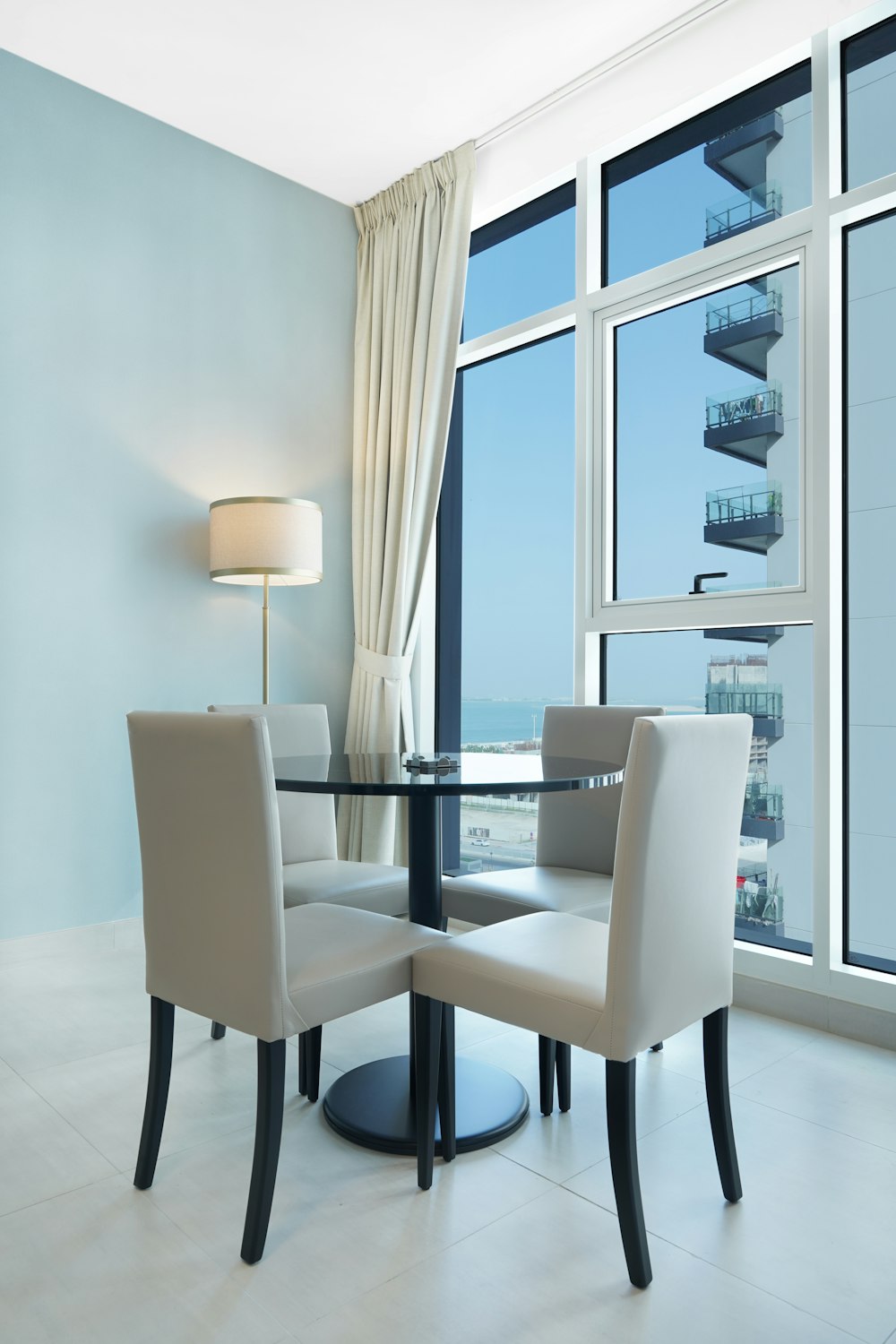 a dining room with a glass table and chairs