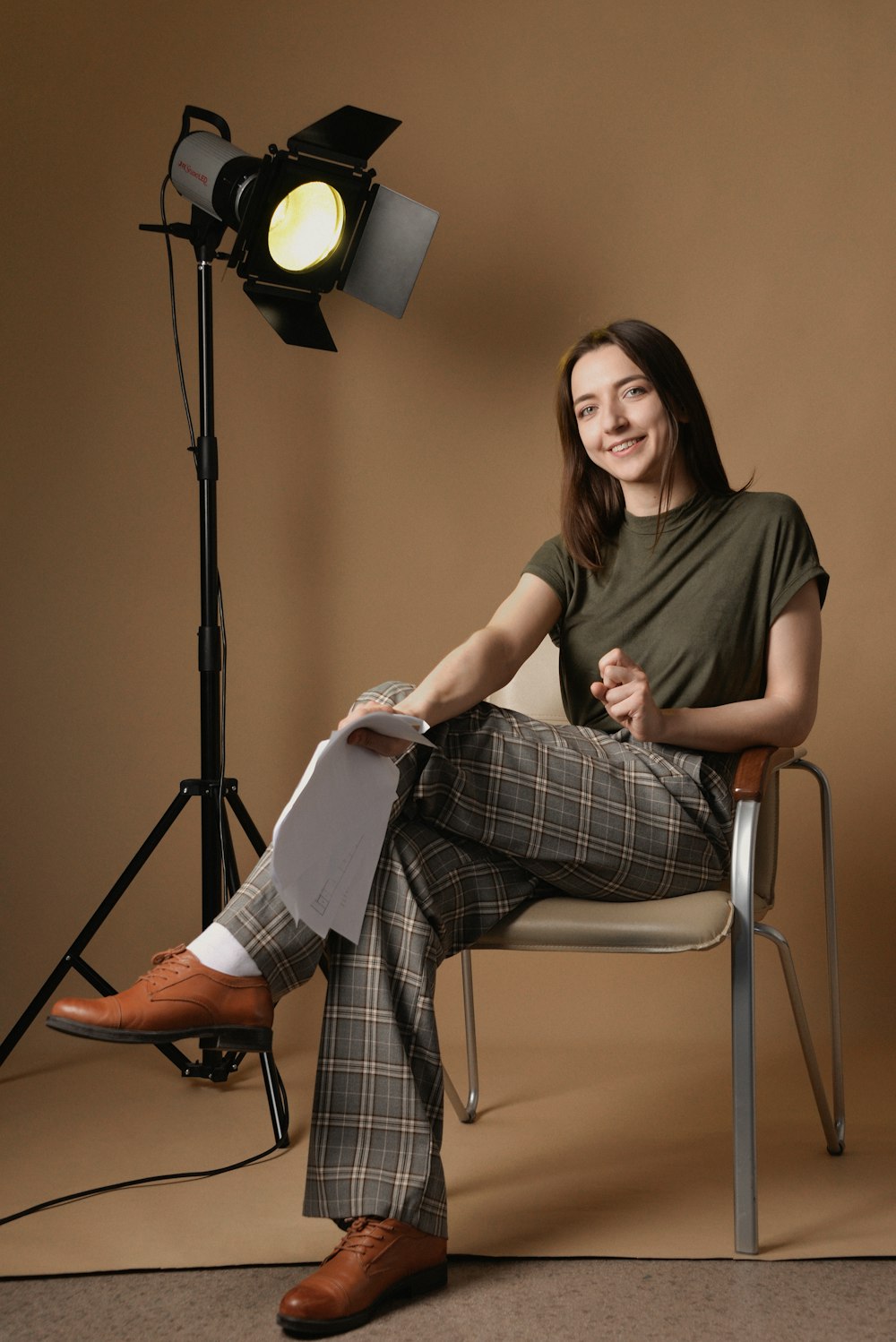 a woman sitting in a chair in front of a light