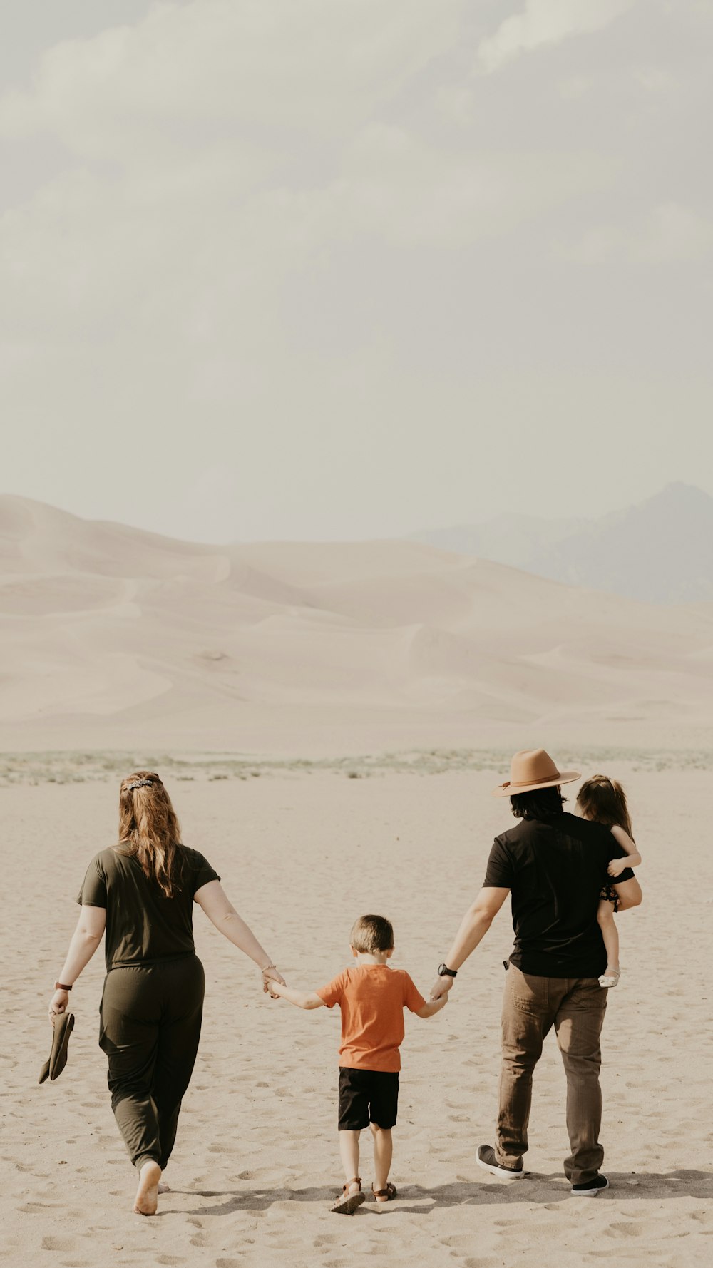 a family walking in the desert holding hands