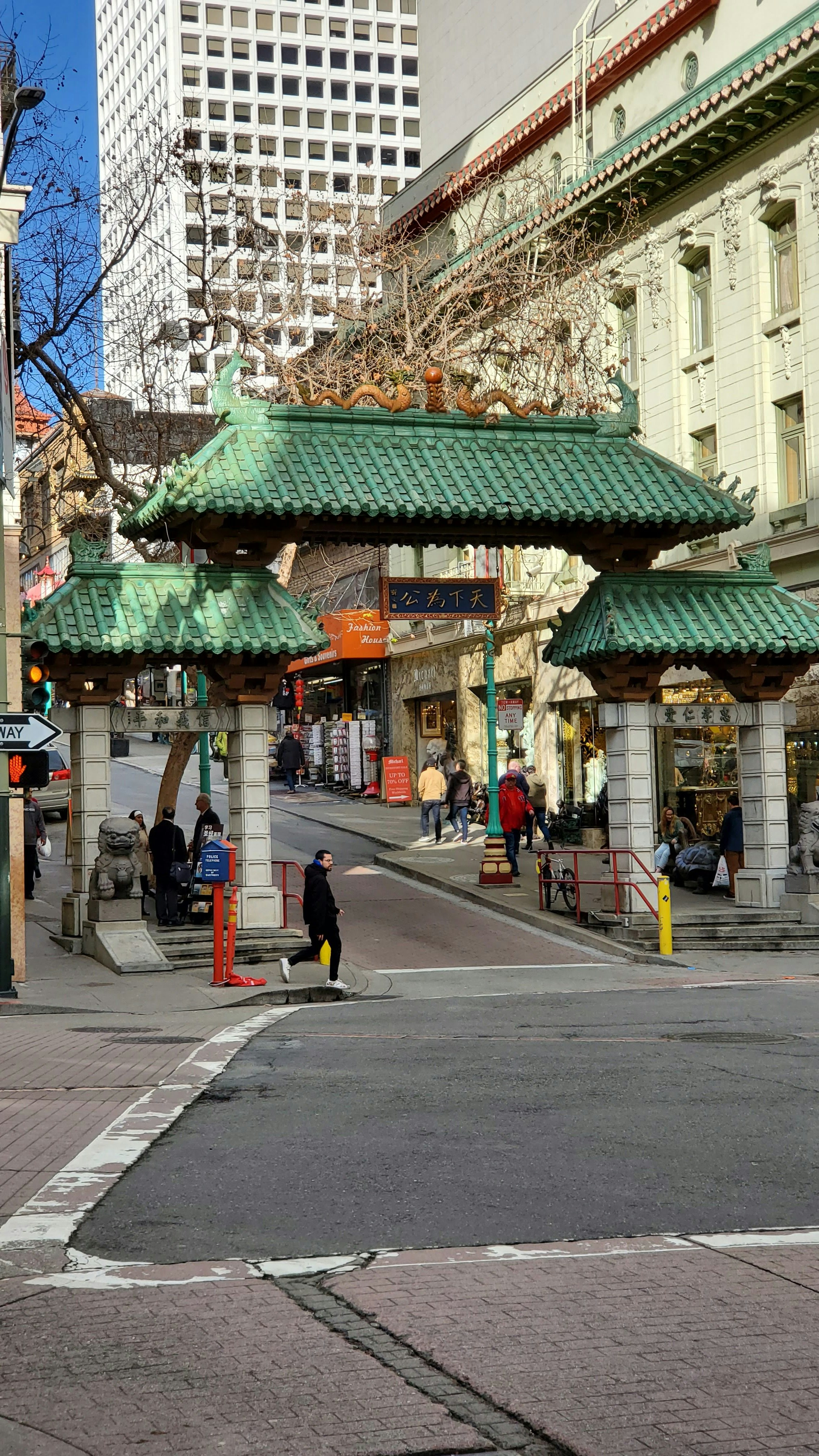 a woman walking across a street holding an umbrella