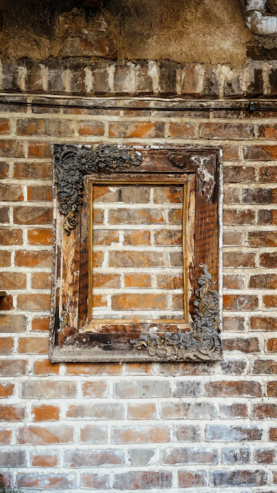 An old picture frame on a brick wall
