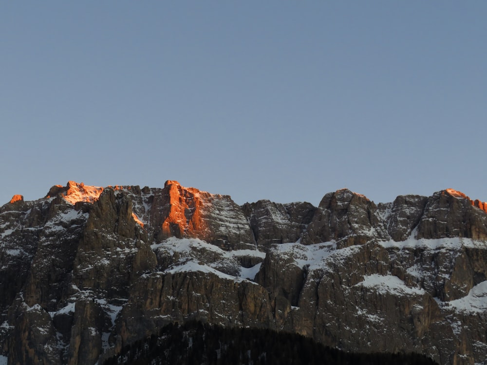 a group of mountains covered in snow under a blue sky