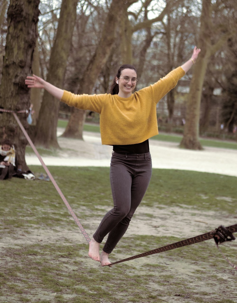 a woman in a yellow sweater is playing frisbee