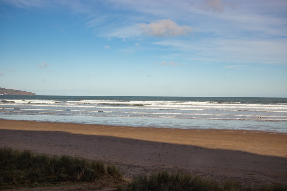 a view of a beach with waves coming in from the ocean