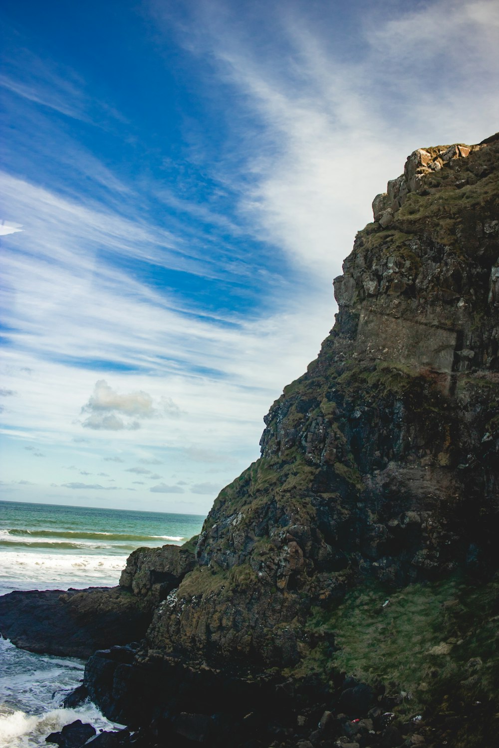 a person sitting on a rock near the ocean