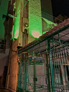 Nighttime exterior view of the nilevanta export warehouse illuminated with soft green and gold lighting
