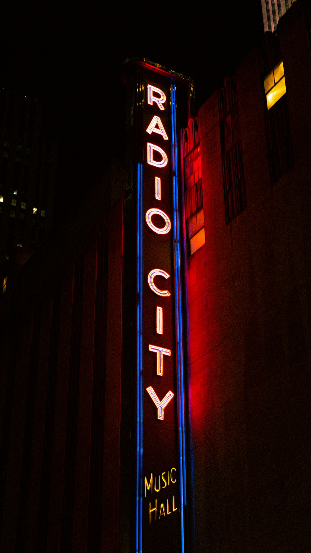 a radio city sign lit up at night
