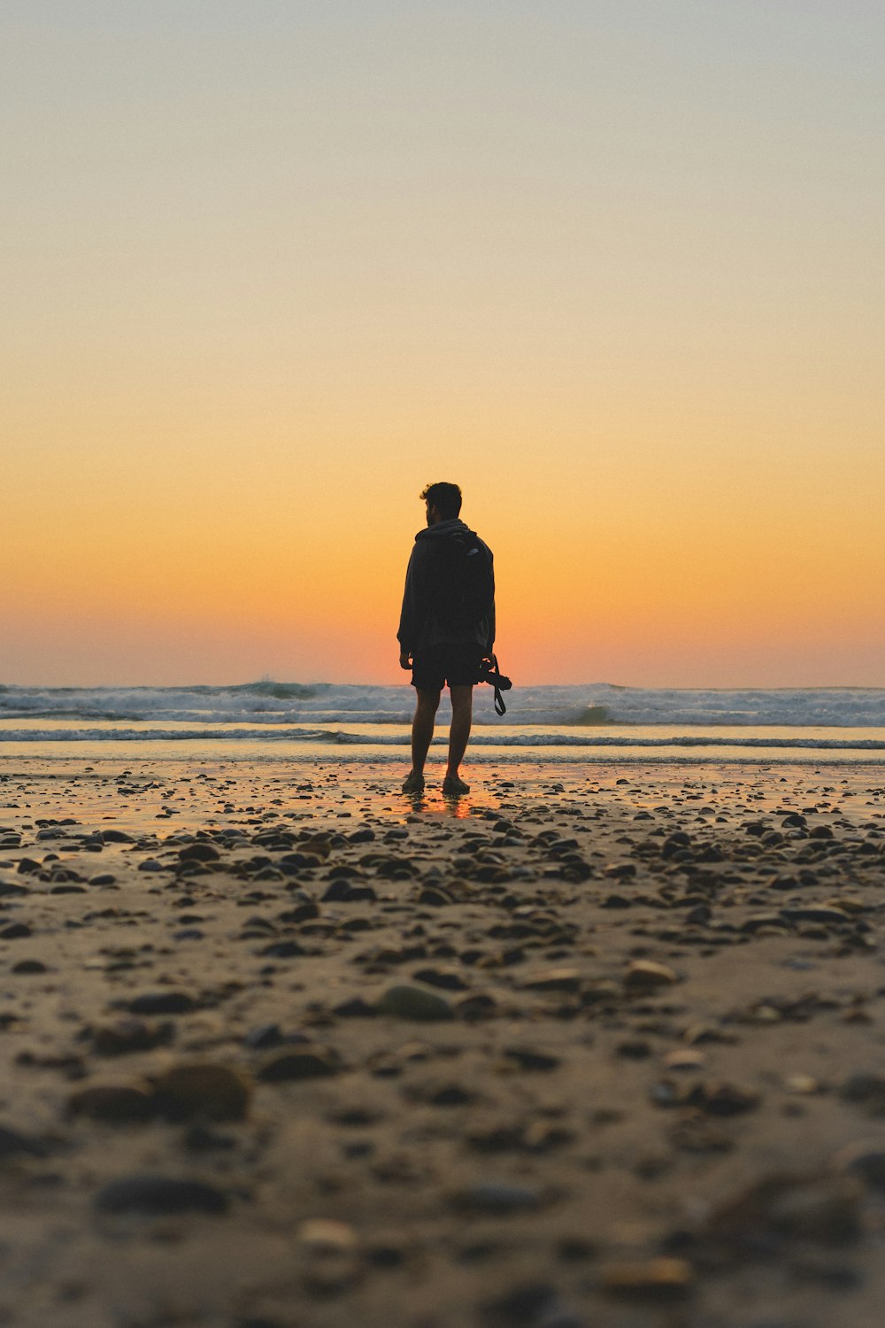 a man standing on top of a sandy beach