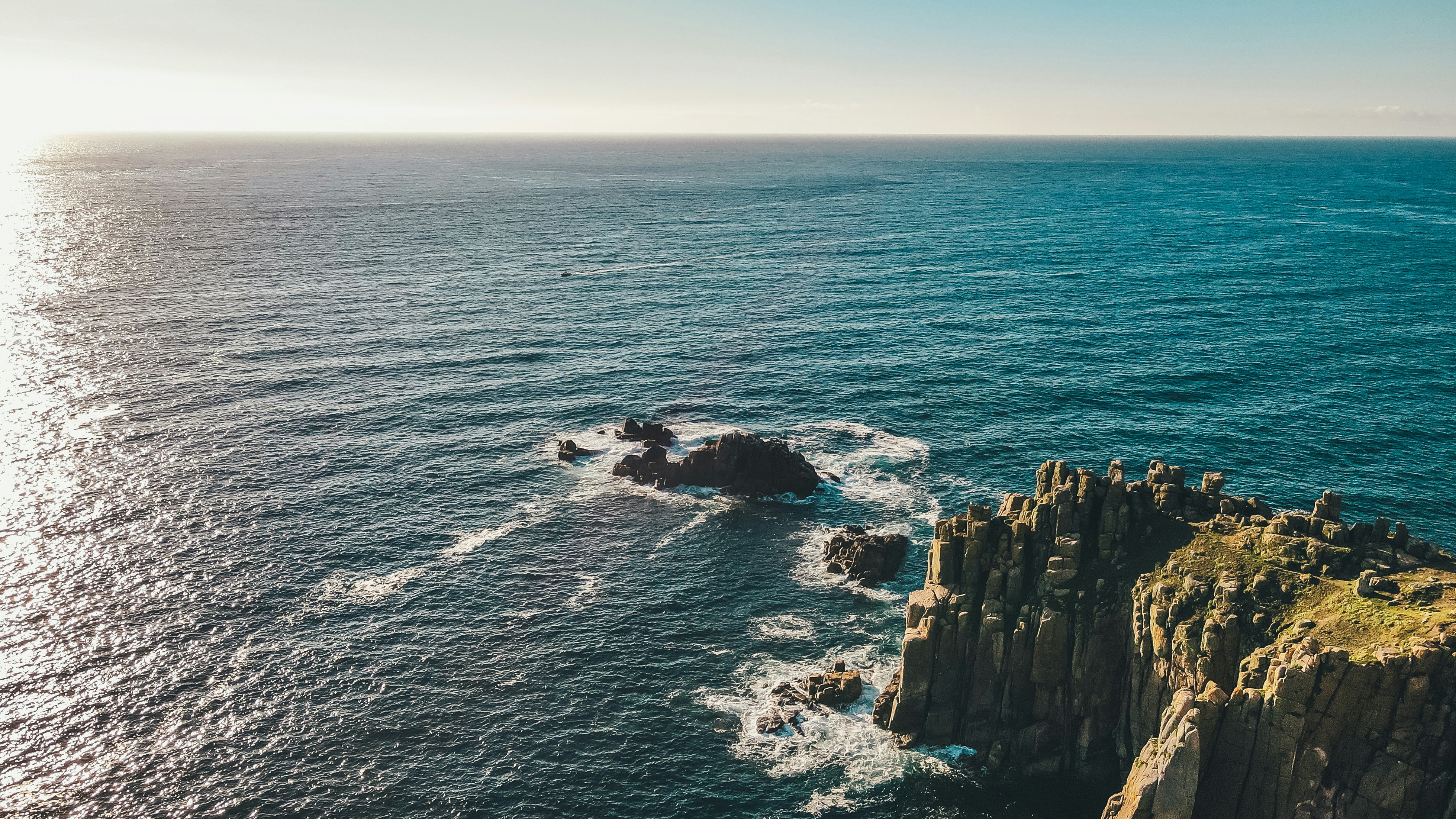 a large body of water with a rock outcropping in the middle of