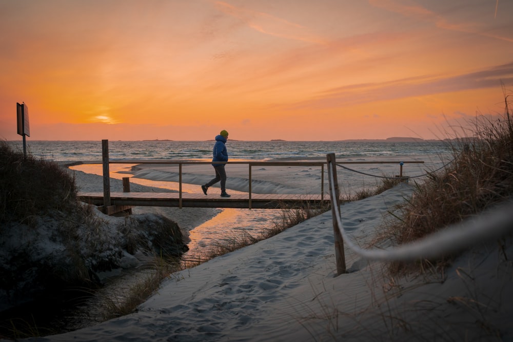 a person walking across a bridge over a body of water