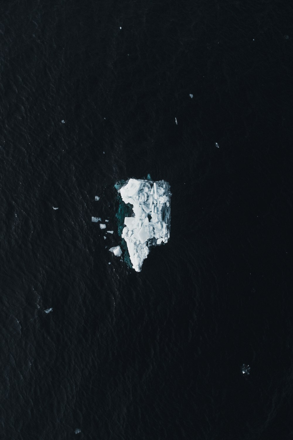 an iceberg floating in the middle of the ocean