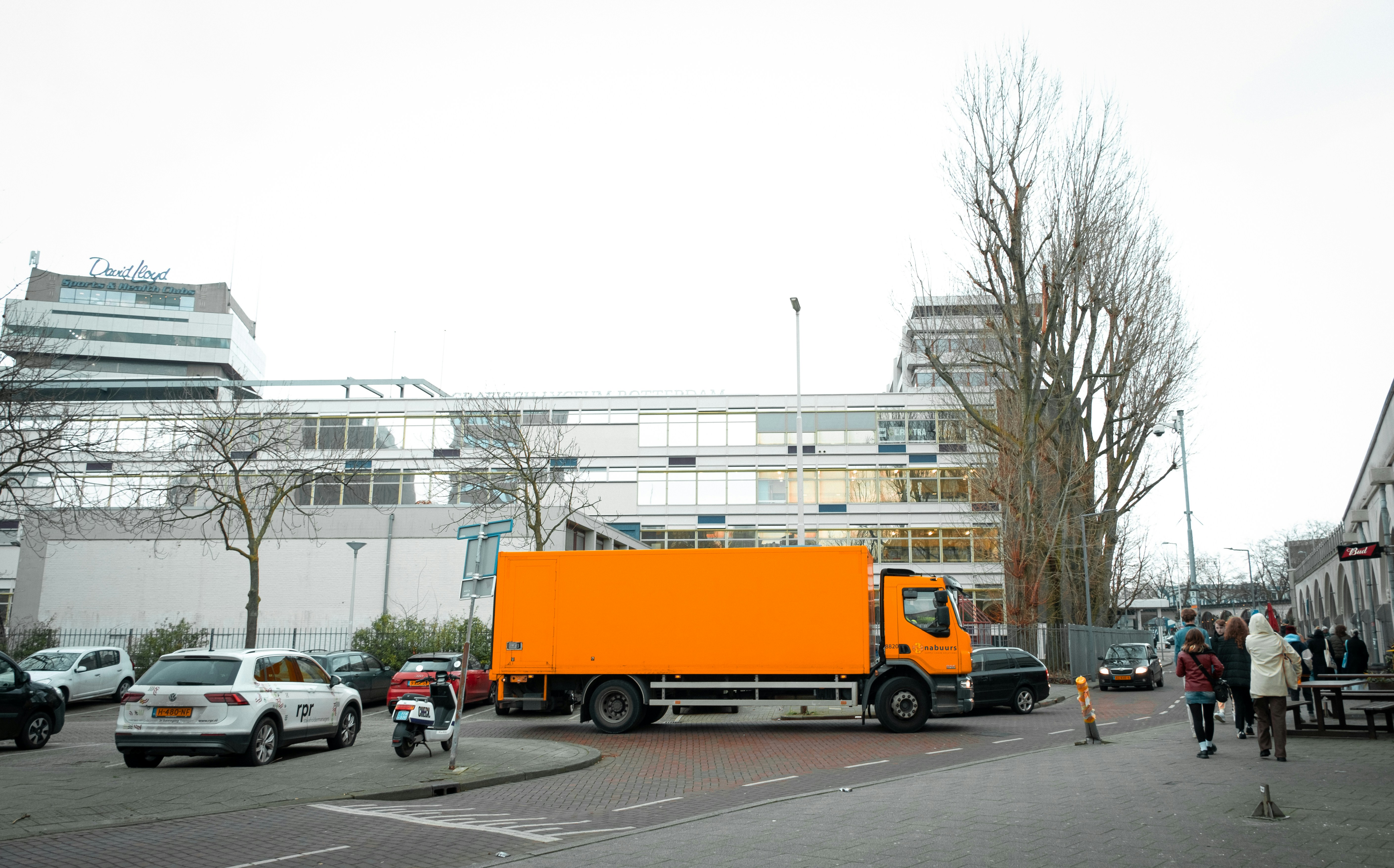 Ein großer orangefarbener LKW parkt auf einem Parkplatz