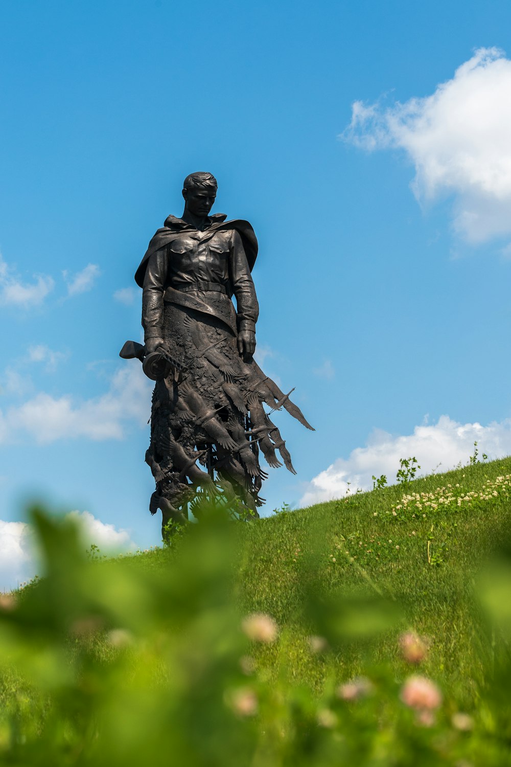 a statue of a man holding a sword on top of a hill