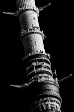 A towering obsidian monolith standing firm against a backdrop of deep shadows, symbolizing unyielding corporate defense.