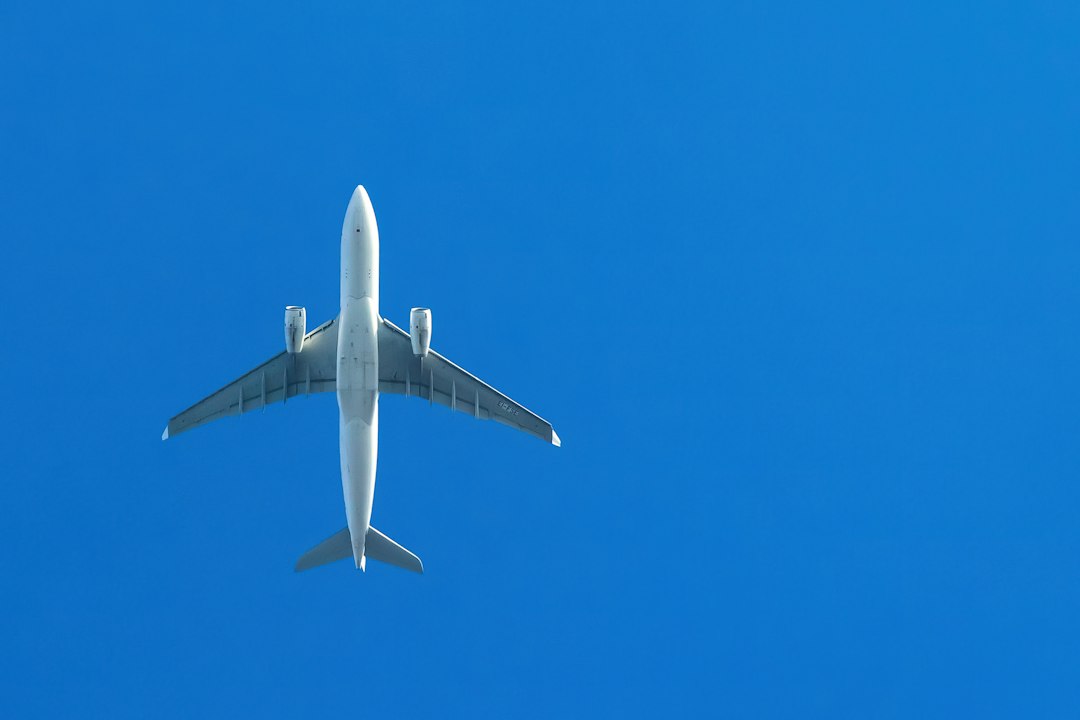 an airplane is flying in the blue sky,