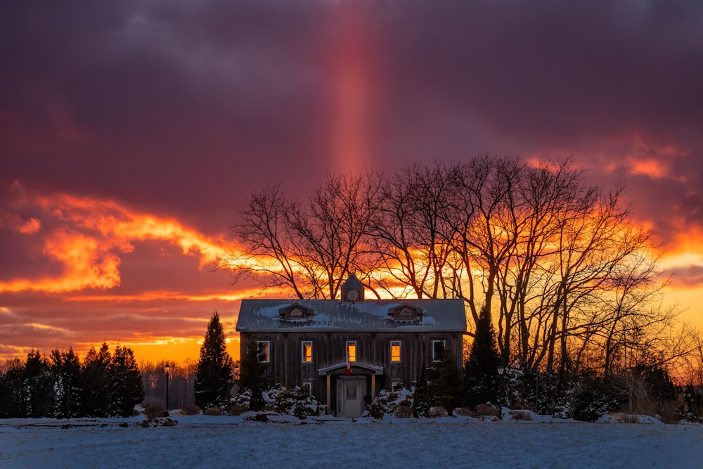 a house in the middle of a snowy field