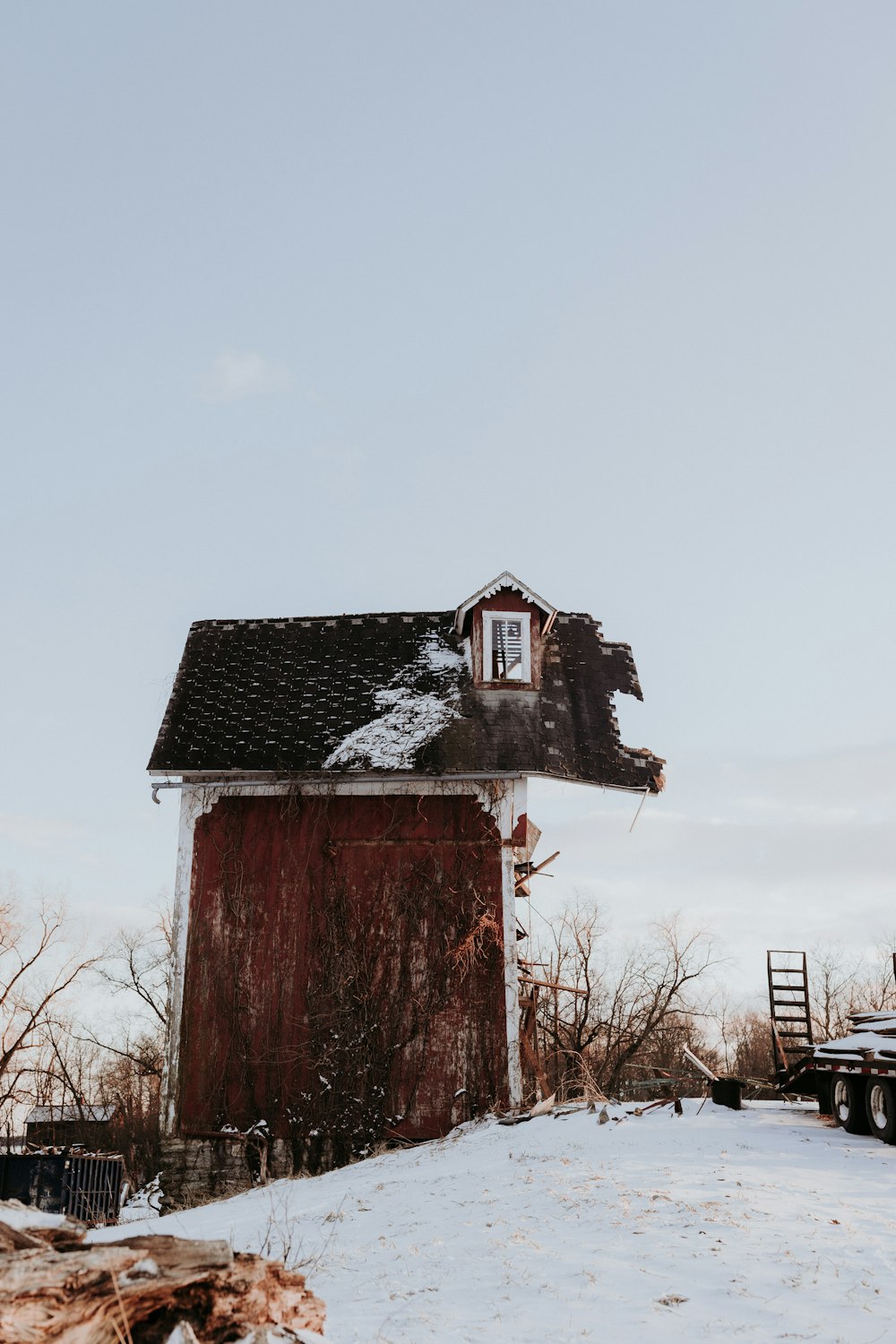 a red barn sitting on top of a snow covered hill