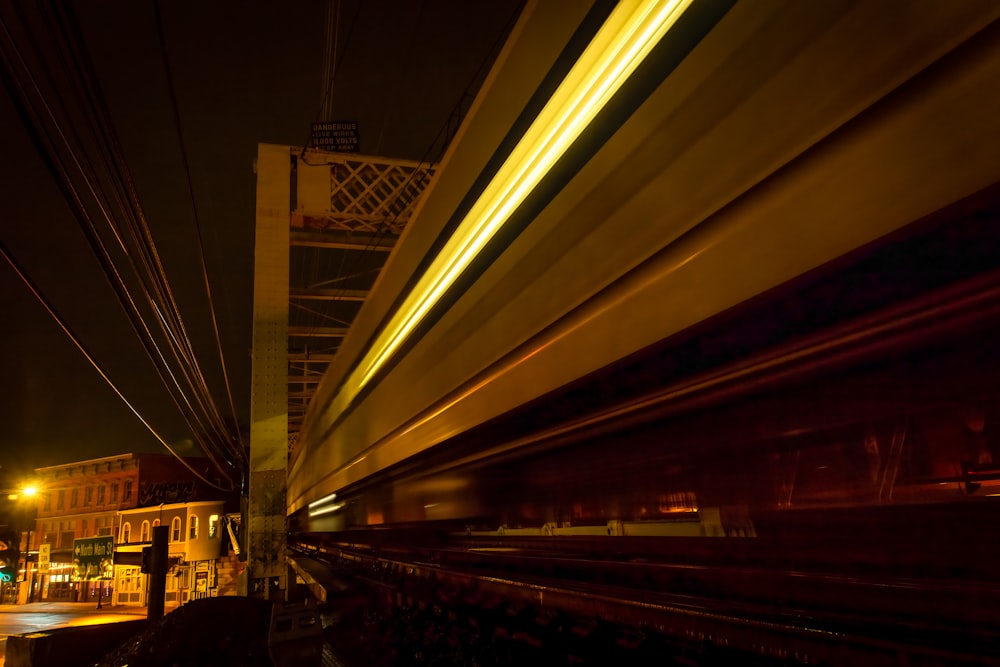a blurry photo of a train passing under a bridge