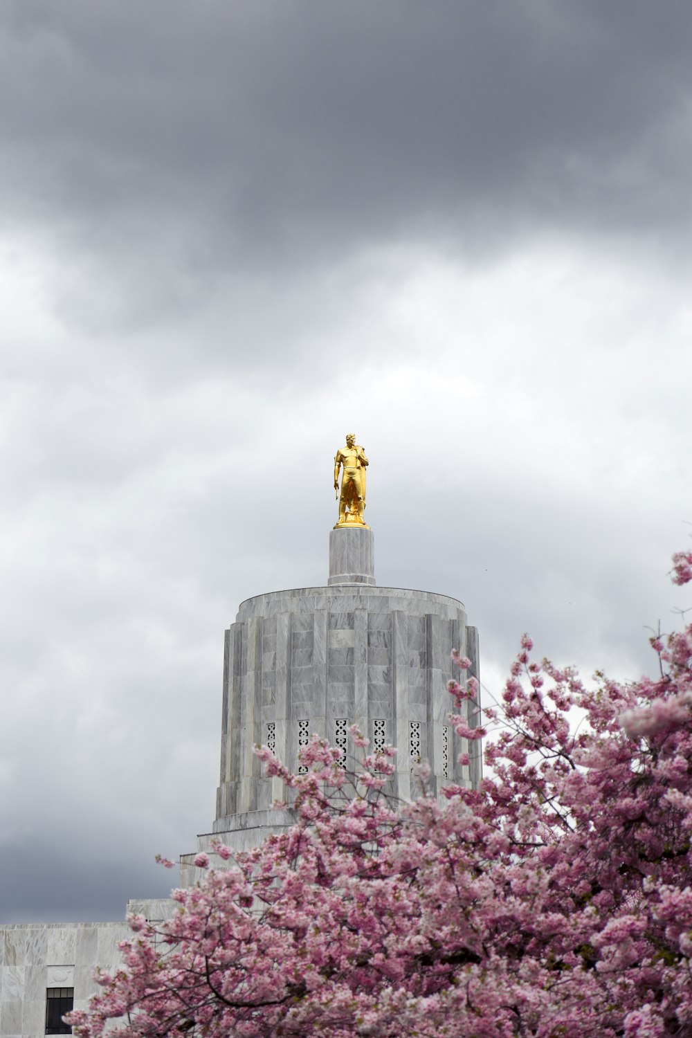 a tall building with a golden statue on top of it