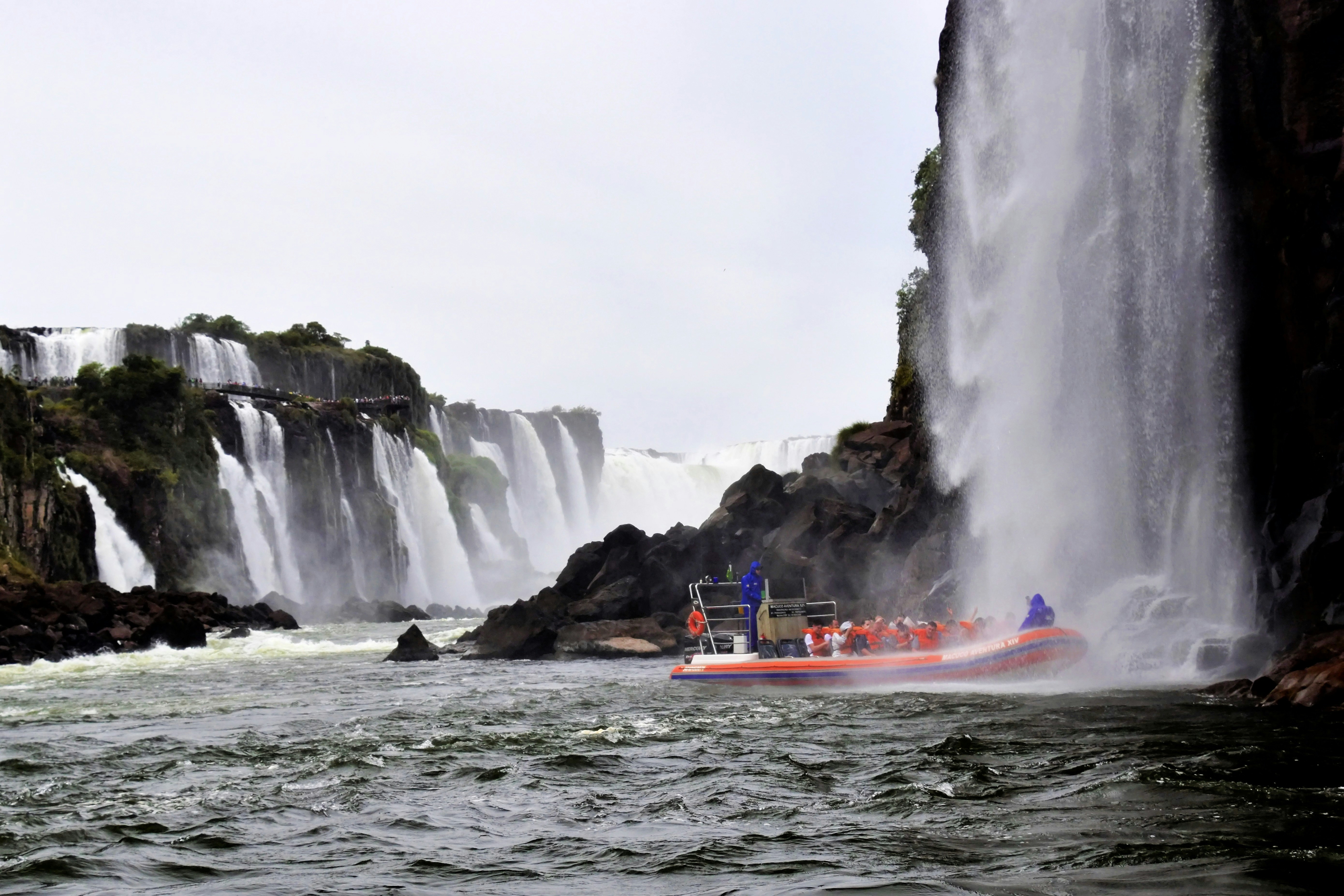 A boat in a body of water near a waterfall photo – Free Land Image on ...