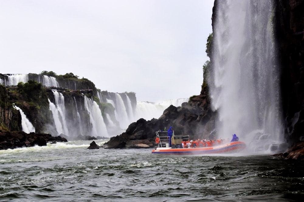 a boat in a body of water near a waterfall
