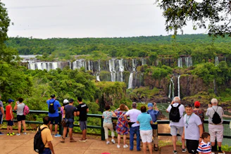A vibrant tour group enjoying the panoramic view of Iguazu Falls from the Brazilian side.