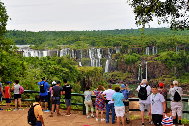 A vibrant tour group enjoying the panoramic view of Iguazu Falls from the Brazilian side.
