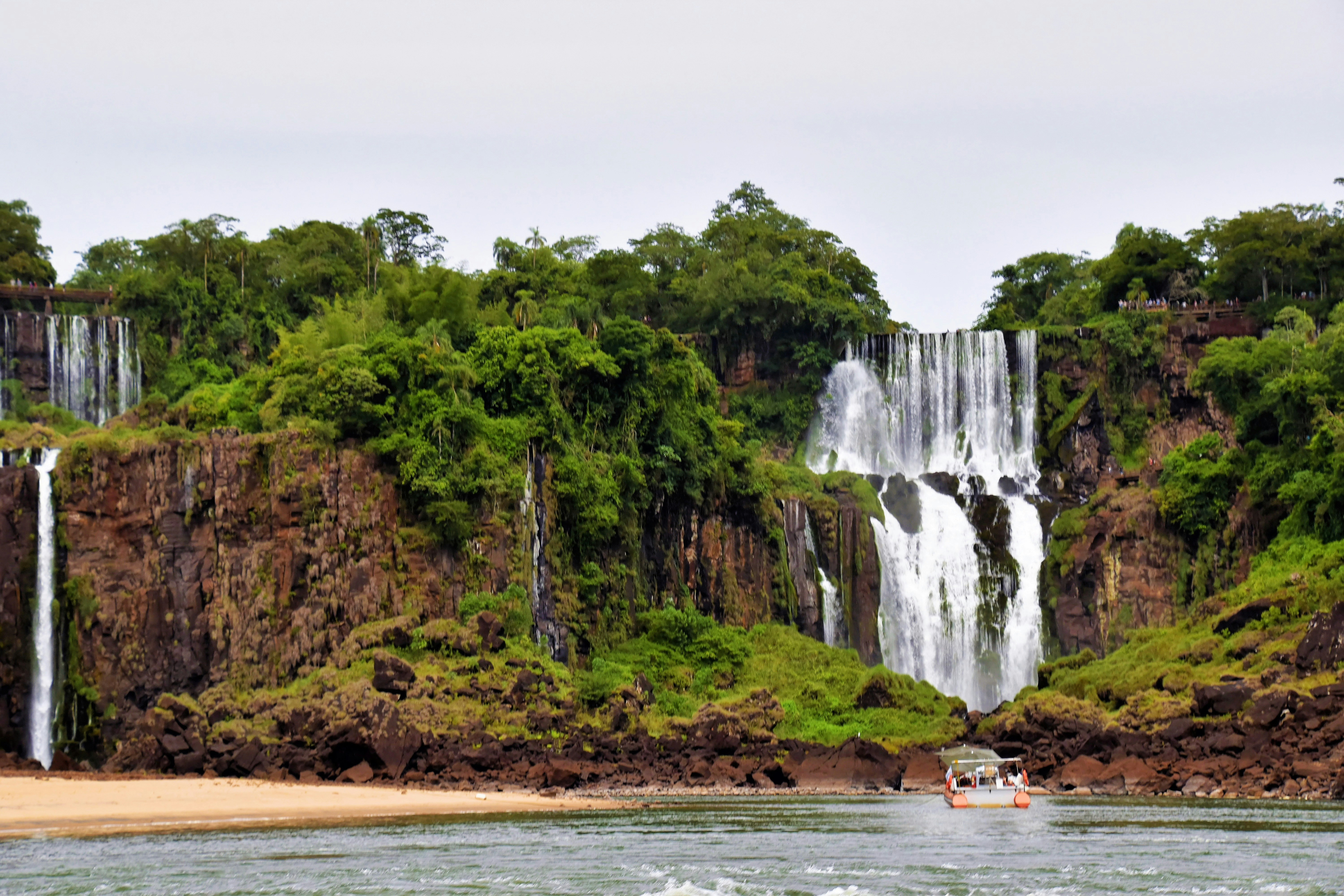 a boat is in the water near a waterfall
