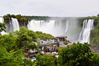 a view of a waterfall with a bridge in the foreground