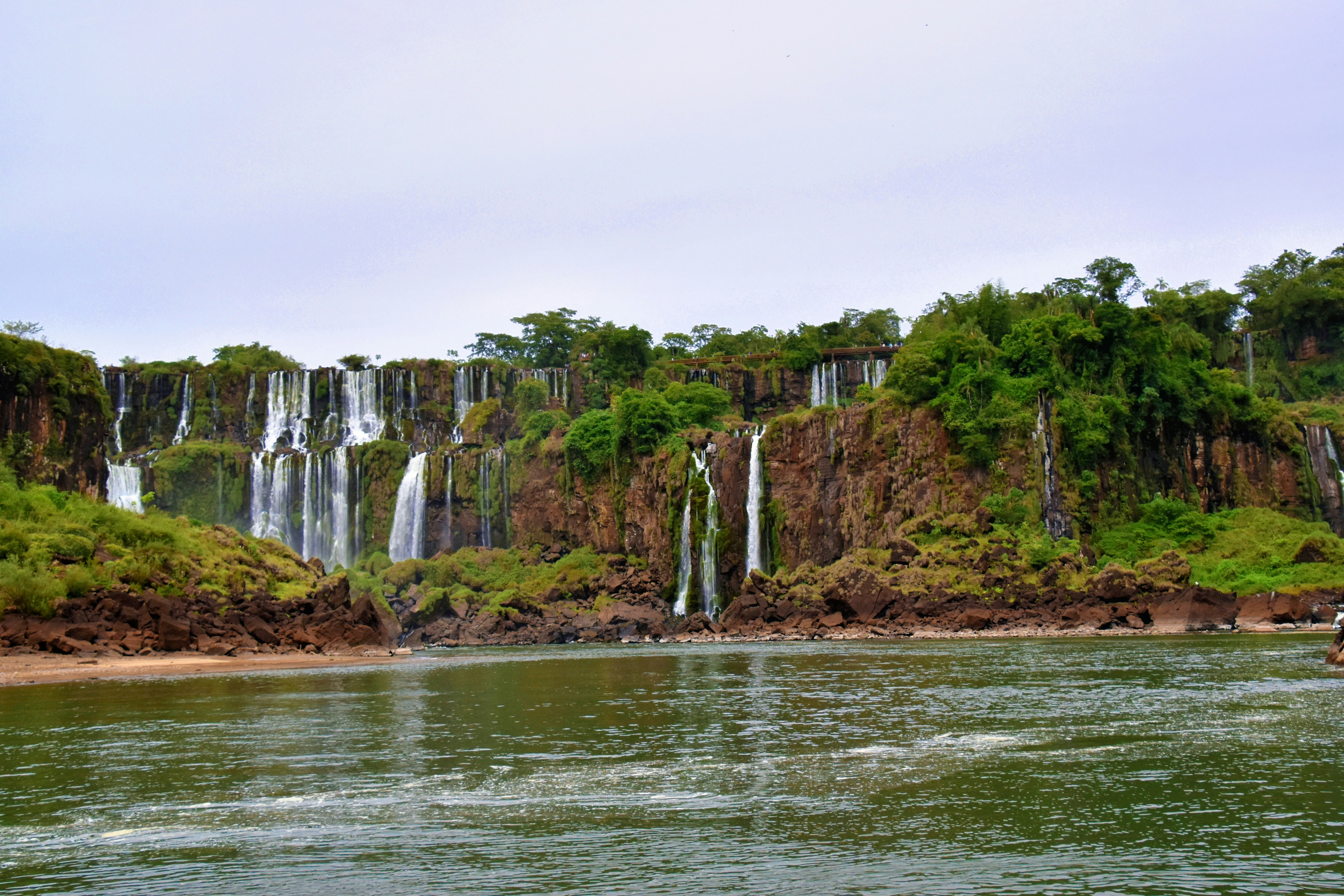 a man riding a boat in front of a waterfall