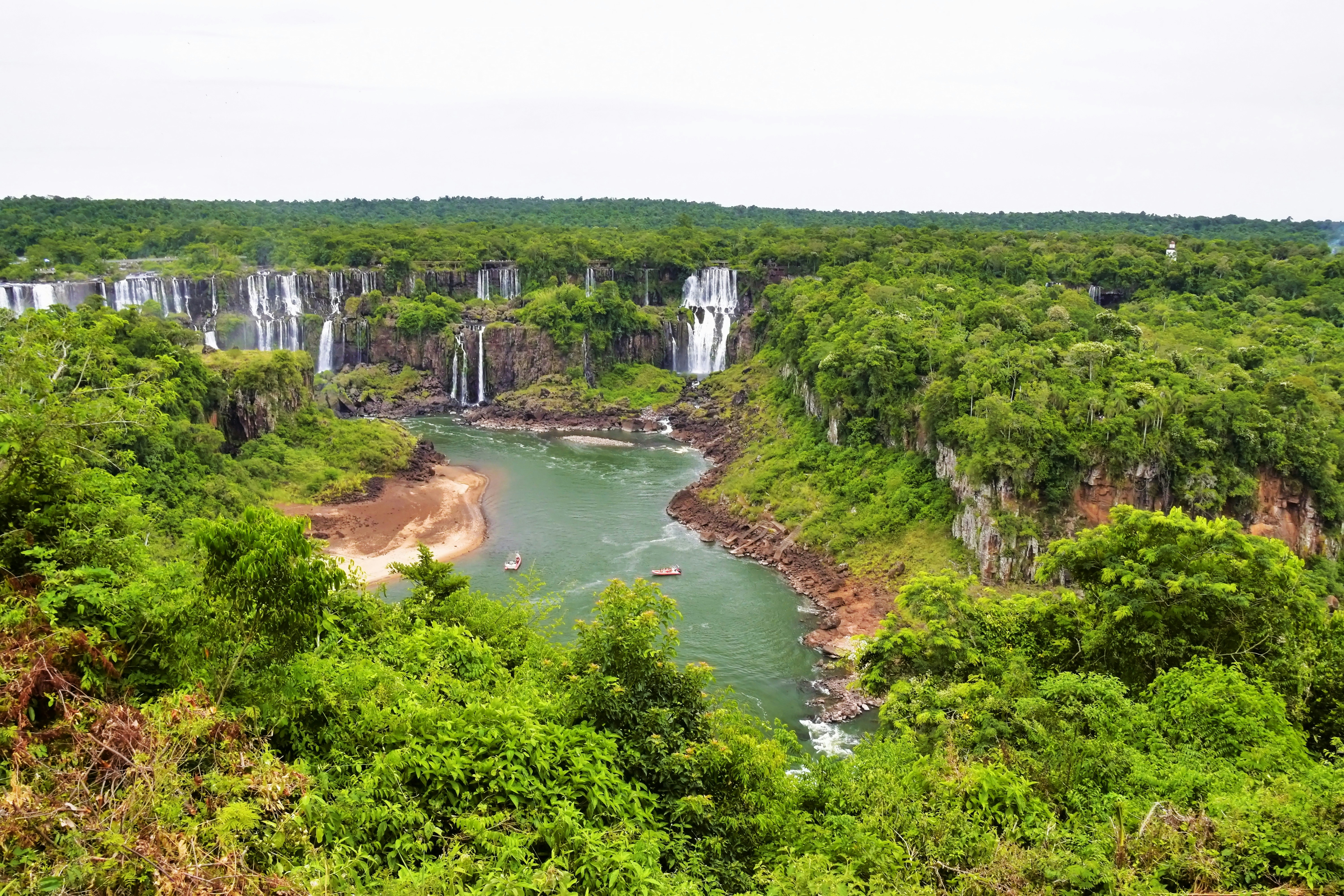 a large waterfall in the middle of a lush green forest