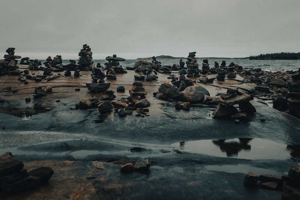 Un grupo de rocas sentadas en la cima de una playa rocosa