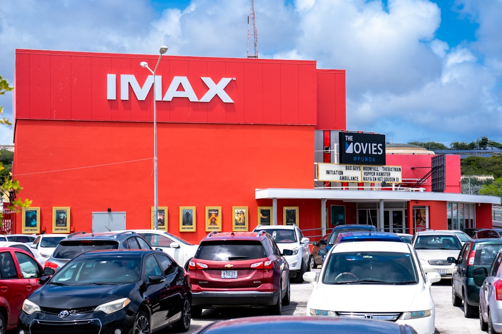 Un groupe de voitures garées devant une salle de cinéma